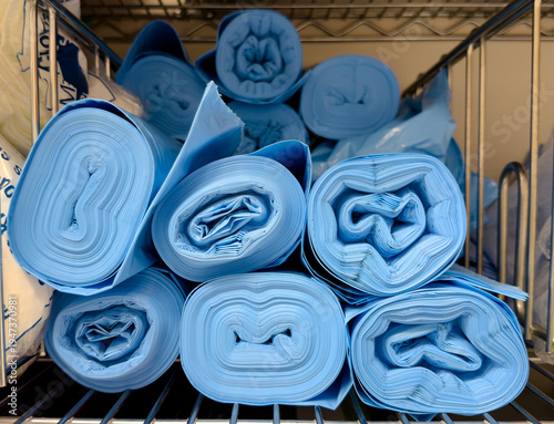 Rolled blue disposable medical bags stored on hospital supply shelf