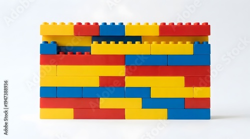 Top view of a colorful pile of plastic building blocks and geometric shapes on a light wooden table