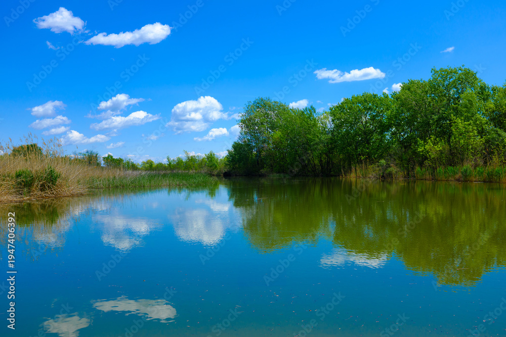 Fototapeta premium The beautiful Tisza lake with a nice reflection of clouds on the water 