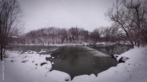 Winter Snow Landscape of Don River Flowing Through Forest in Toronto Canada, Frozen Riverbank and Bare Trees During Overcast Cold Day