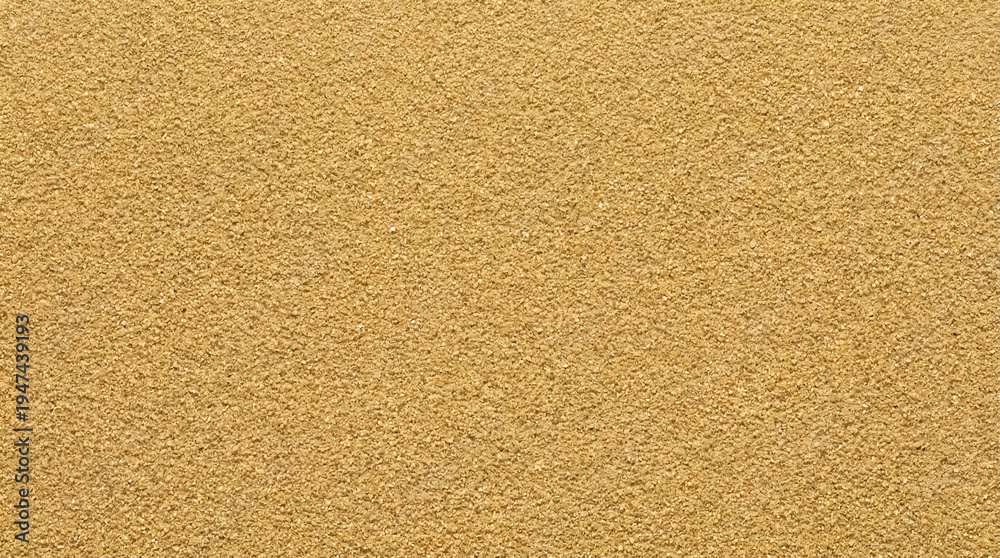 Fototapeta premium A full frame close-up shot of very fine-grained golden sand showcasing its uniform texture and warm, inviting color under natural light conditions.