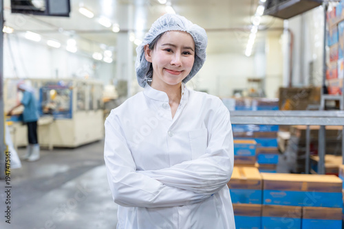 Cuadro en lienzo Portrait of professional female worker in white lab coat with arms crossed at fo