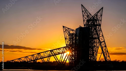 Industrial structure silhouette against a vibrant sunset sky.