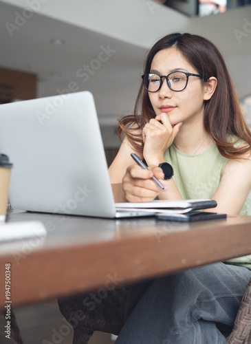 Focused woman working at laptop thinking of problem solving during working at cafe or home office, vertical