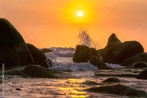 Wallpaper Mural Sunrise landscape at tropical beach. The warm golden light of illuminating the sea spray creates a striking silhouette of the rocks against the glowing sky Torontodigital.ca