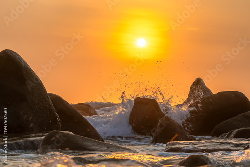 Wallpaper Mural Sunrise landscape at tropical beach. The warm golden light of illuminating the sea spray creates a striking silhouette of the rocks against the glowing sky Torontodigital.ca