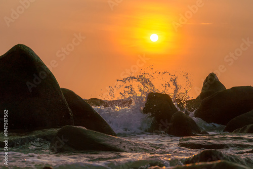 Wallpaper Mural Sunrise landscape at tropical beach. The warm golden light of illuminating the sea spray creates a striking silhouette of the rocks against the glowing sky Torontodigital.ca