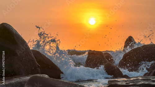 Wallpaper Mural Sunrise landscape at tropical beach. The warm golden light of illuminating the sea spray creates a striking silhouette of the rocks against the glowing sky Torontodigital.ca
