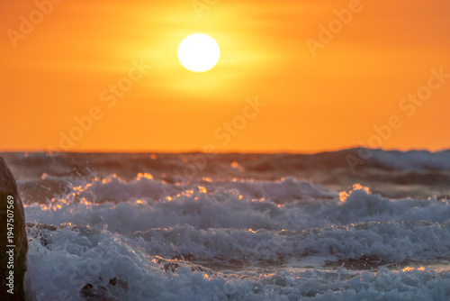 Wallpaper Mural Sunrise landscape at tropical beach. The warm golden light of illuminating the sea spray creates a striking silhouette of the rocks against the glowing sky Torontodigital.ca