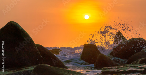 Wallpaper Mural Sunrise landscape at tropical beach. The warm golden light of illuminating the sea spray creates a striking silhouette of the rocks against the glowing sky Torontodigital.ca