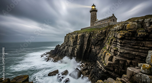 Dramatic lighthouse on rugged cliff overlooking stormy ocean waves under dark cloudy sky