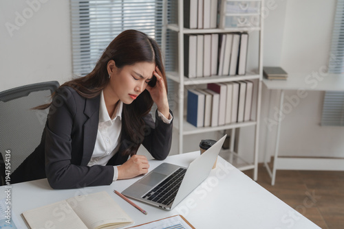 Bilde på lerret Stressed businesswoman suffering headache working on laptop