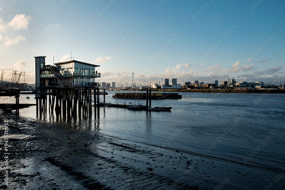 Fototapeta premium Modern stilt building on river thames at low tide