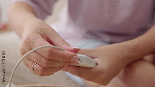Woman unsuccessfully trying to connect charging cable to power bank, problem with smartphone charging