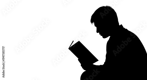 Man reading a book in silhouette.