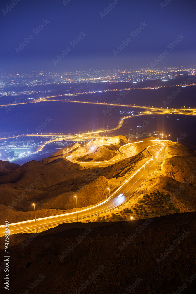 Naklejka premium Night view of curvy windy mountain roads with street lights on Jebel Hafeet mountain in Al Ain, Abu Dhabi