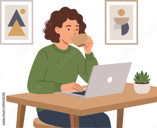 Woman sits at desk working on laptop while drinking coffee indoors