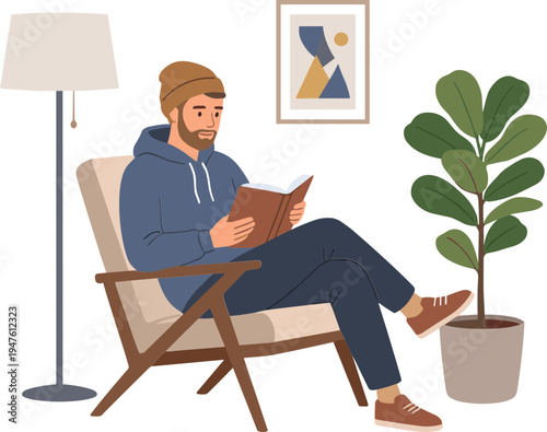 A man sits in a chair reading a book at home next to a plant and lamp.