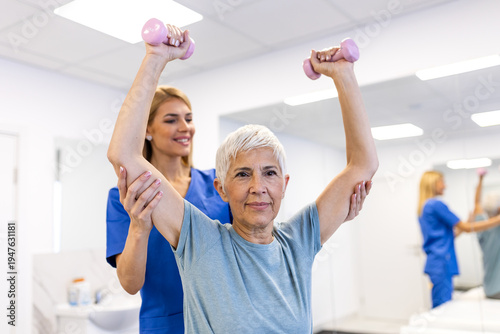Принти на полотні Senior woman exercising with dumbbells during physical therapy with a doctor
