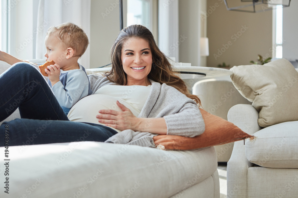 Obraz premium Relax, sofa and pregnant mom with toddler in home for bonding, calm or connection together. Happy, pregnancy and mother laying with boy child for maternal, care or love in living room at house.