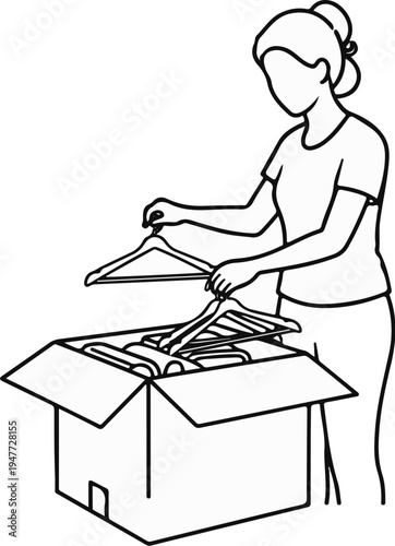 Person packing clothes into a cardboard box using hangers