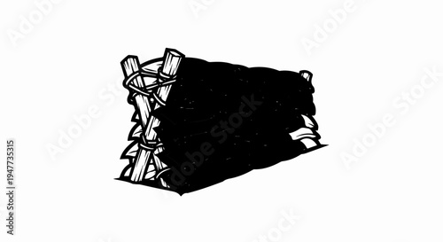 Stack of dark, folded materials secured by bamboo poles and rope