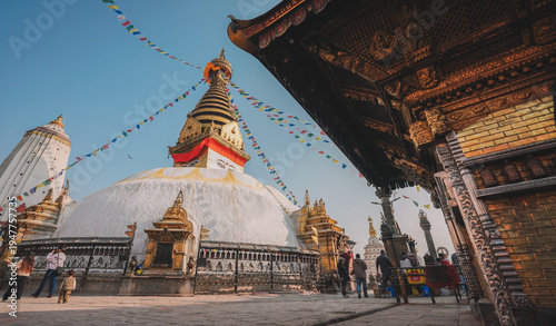 Ancient Buddhist Stupa with Golden Spire and Colorful Prayer Flags