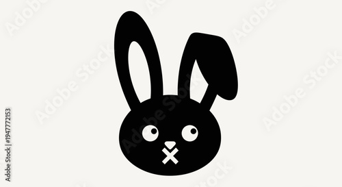 Black rabbit head with large ears and a cross over its mouth.