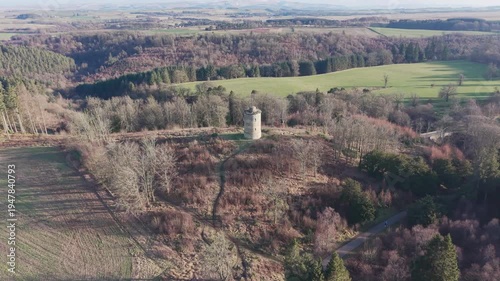 Aerial view of the historic Knight's Law Tower dovecot near Old Penicuik House: A 18th century folly surrounded by the rolling hills of Midlothian