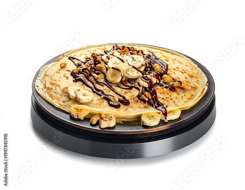 Cr?pe topped with sliced bananas, nuts, and chocolate drizzle sits on a round, black, electric griddle