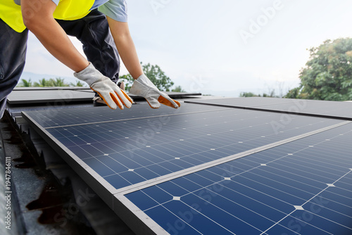 Technician inspecting solar panel installation on rooftop for renewable energy system safety