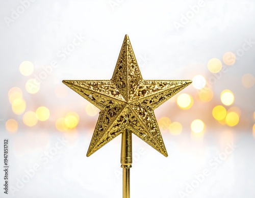 Golden five-pointed star with intricate details atop a rod against a bokeh background of round, soft yellow lights