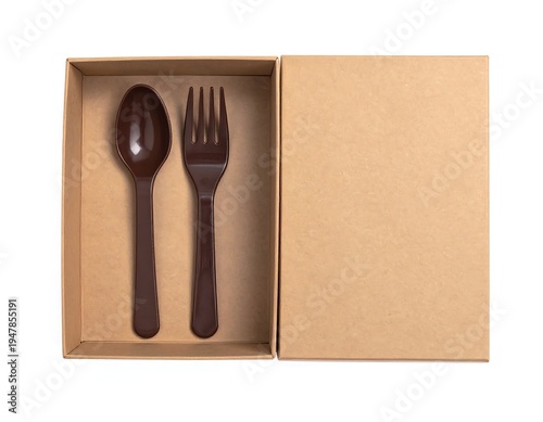 Overhead shot of a brown spoon and fork set inside an open brown cardboard box. The other half of the box is empty