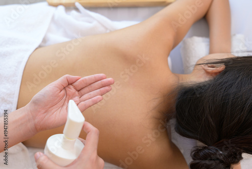 Serene spa wellness treatment with massage oil apply on woman back in beauty salon relaxation setting