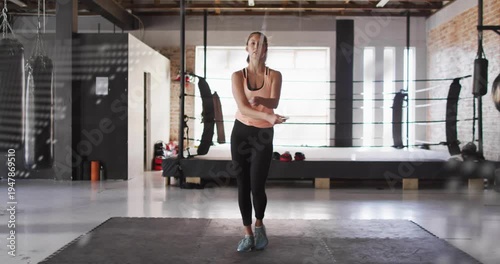 Woman starting skipping on mat in gym for fitness, dotted map overlay scrolling obscuring movement