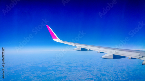Plane wing glides above fluffy white clouds