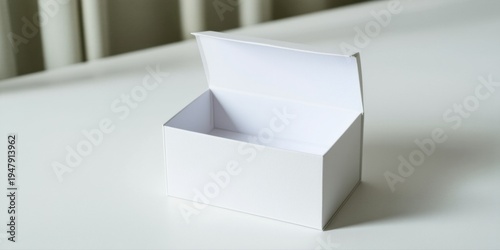 Open white box rests upon surface. Minimalist aesthetic, clean lines, simple presentation. Shadow defines shape, highlighting emptiness.