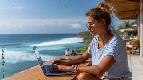Laptop by the Sea: A person working on their laptop enjoying scenic seaside view in the daylight, embracing the joy of a perfect workation.