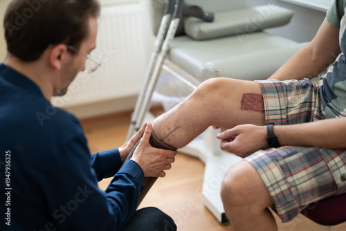 Physical therapist examining a wounded Ukrainian soldier's leg before prosthetic fitting