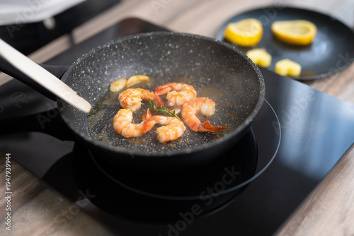 Tableau sur toile Sizzling shrimp with garlic and fresh herbs in a frying pan