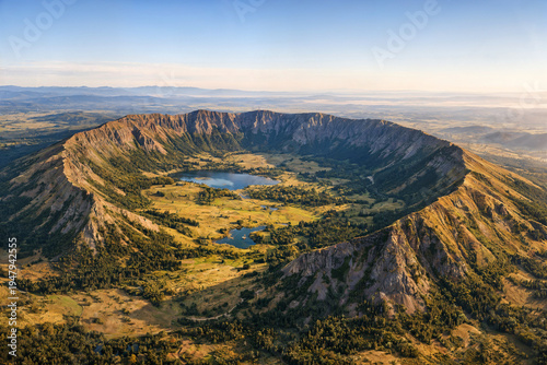 Volcanic crater with lakes grass and forest in morning light