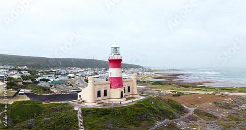 Drone aerial view of Cape Agulhas Lighthouse overlooking the coastline and ocean at the southernmost tip of Africa in the Western Cape, South Africa.