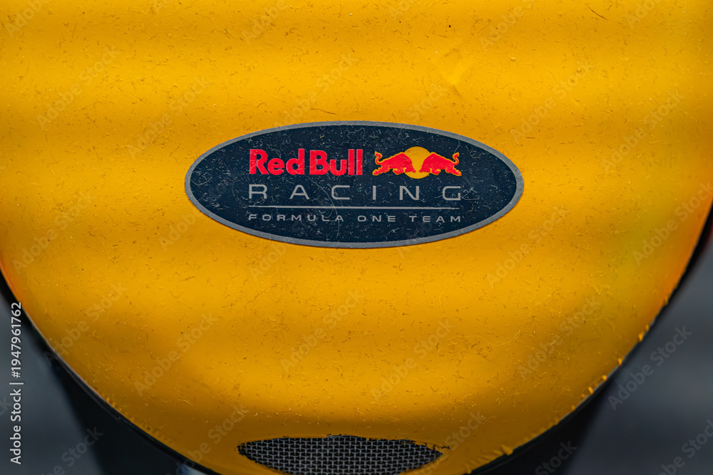 Fototapeta premium Close-up view of a yellow Red Bull Formula One car, prominently displaying the Red Bull logo on a black background The vehicle is vibrant and dynamic with red, blue - Kyiv, Ukraine - June 8, 2025
