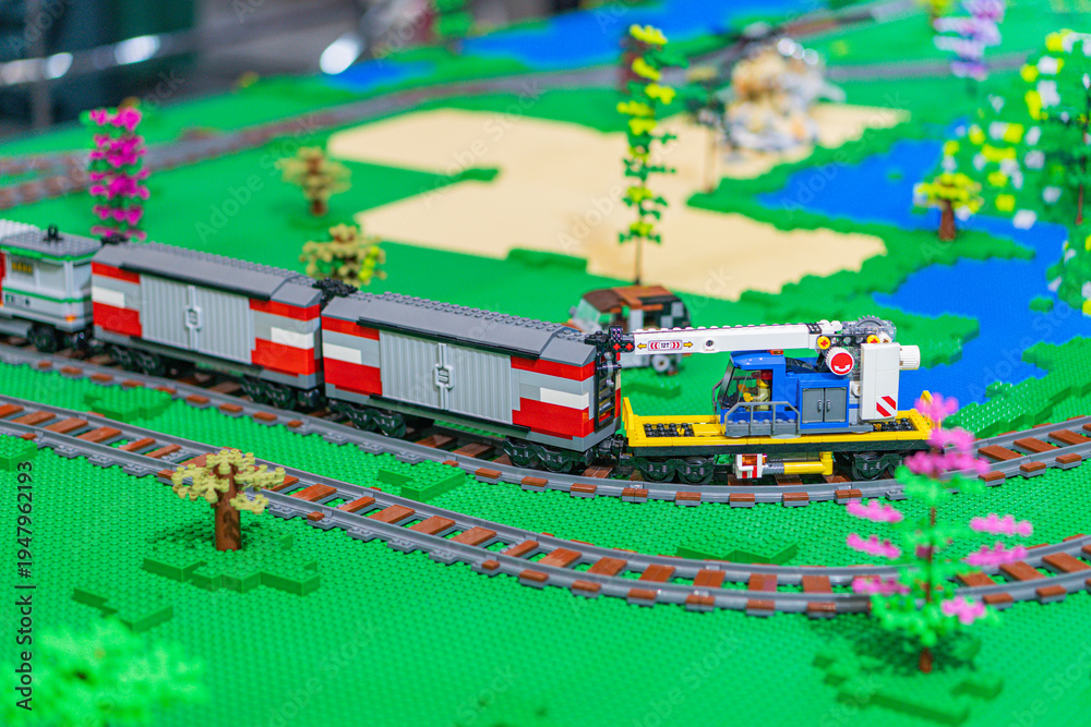 Obraz premium Lego train set in a miniature village landscape, featuring a red and white train with gray accents on curving tracks Buildings and greenery strategically placed for - Kyiv, Ukraine - June 7, 2025