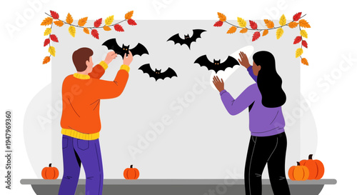 Couple Decorating Wall with Halloween Bats and Autumn Leaves