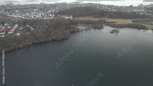 Wallpaper Mural Aerial drone footage showing a lake under moody weather conditions. The scene features calm water, subdued lighting, and overcast skies, presenting a quiet natural landscape with minimal movement and  Torontodigital.ca