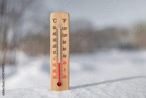White celsius and fahrenheit scale thermometer in snow. Ambient temperature minus 5 degrees celsius