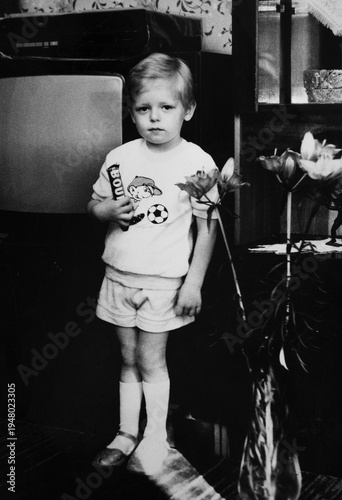 Little boy holding chocolate bar, authentic 1990s family snapshot, nostalgic retro childhood moment