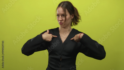Photography Young hispanic woman pointing to chest with both index fingers in lime green studio, open mouth and wide eyes; indignation disbelief