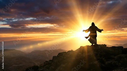 Silhouette of Jesus Christ standing on top of a mountain during sunrise. Catholic religious figure with arms outstretched under glowing golden morning sunlight.